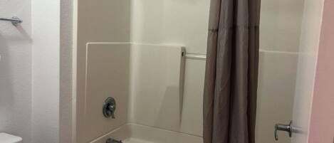 Ein Badezimmer mit Badewanne, Toilette und Duschvorhang.