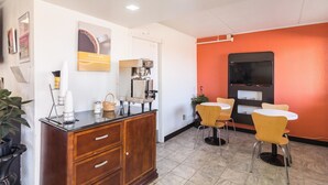Un café moderne doté d’une machine à café, d’un espace salon et d’un comptoir avec un tableau affichant le menu.