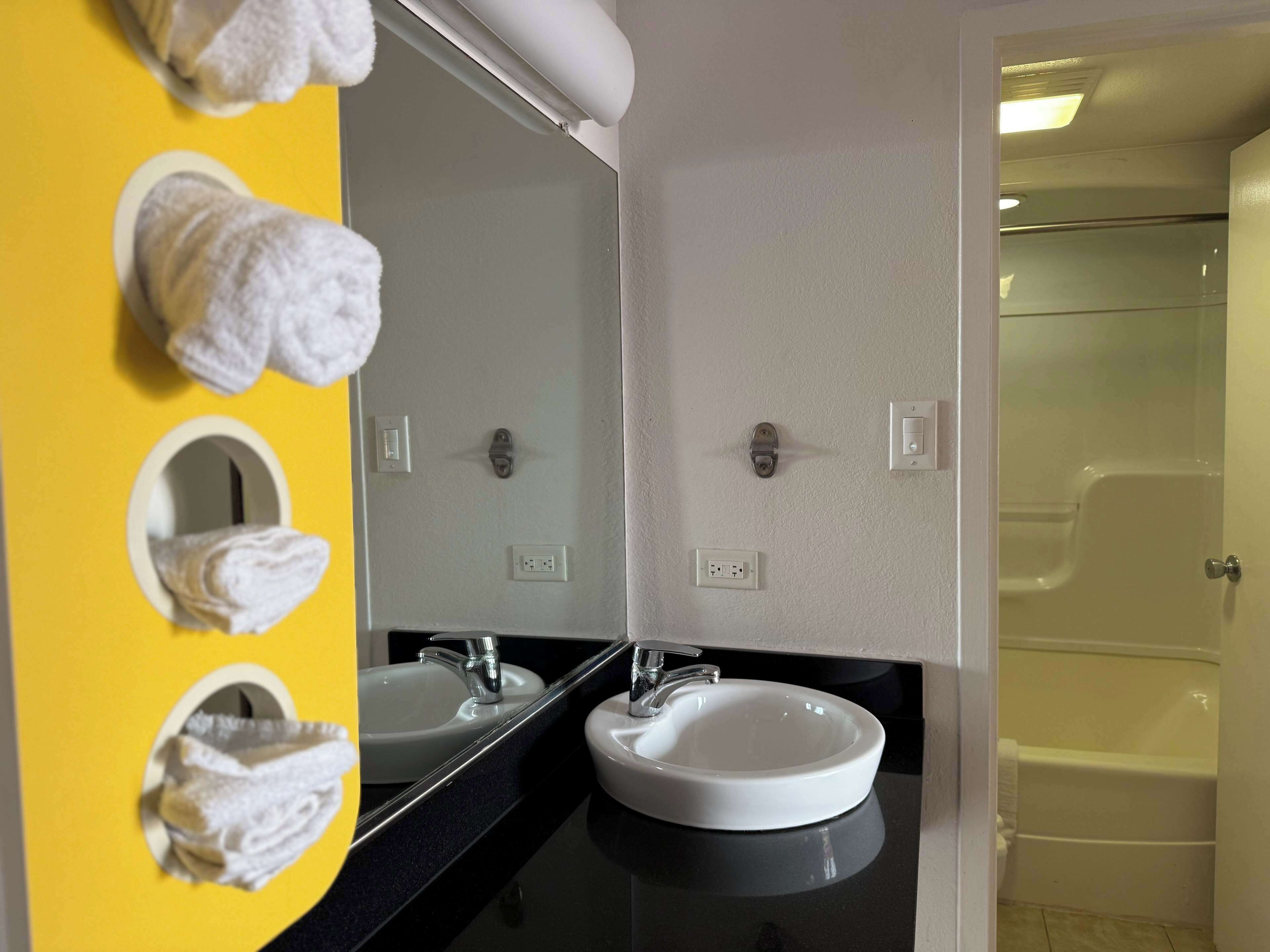 A bathroom with two sinks, a mirror, and a shower.
