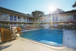 A pool area with lounge chairs and a lifeguard sign. - North Charleston Lodge (North Charleston)