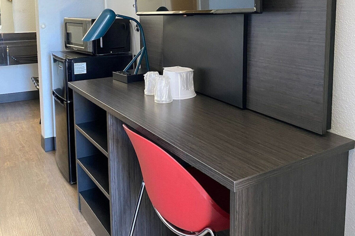 A modern kitchenette with a microwave, a coffee maker, and a small refrigerator.