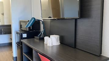 A modern kitchenette with a microwave, a coffee maker, and a small refrigerator.