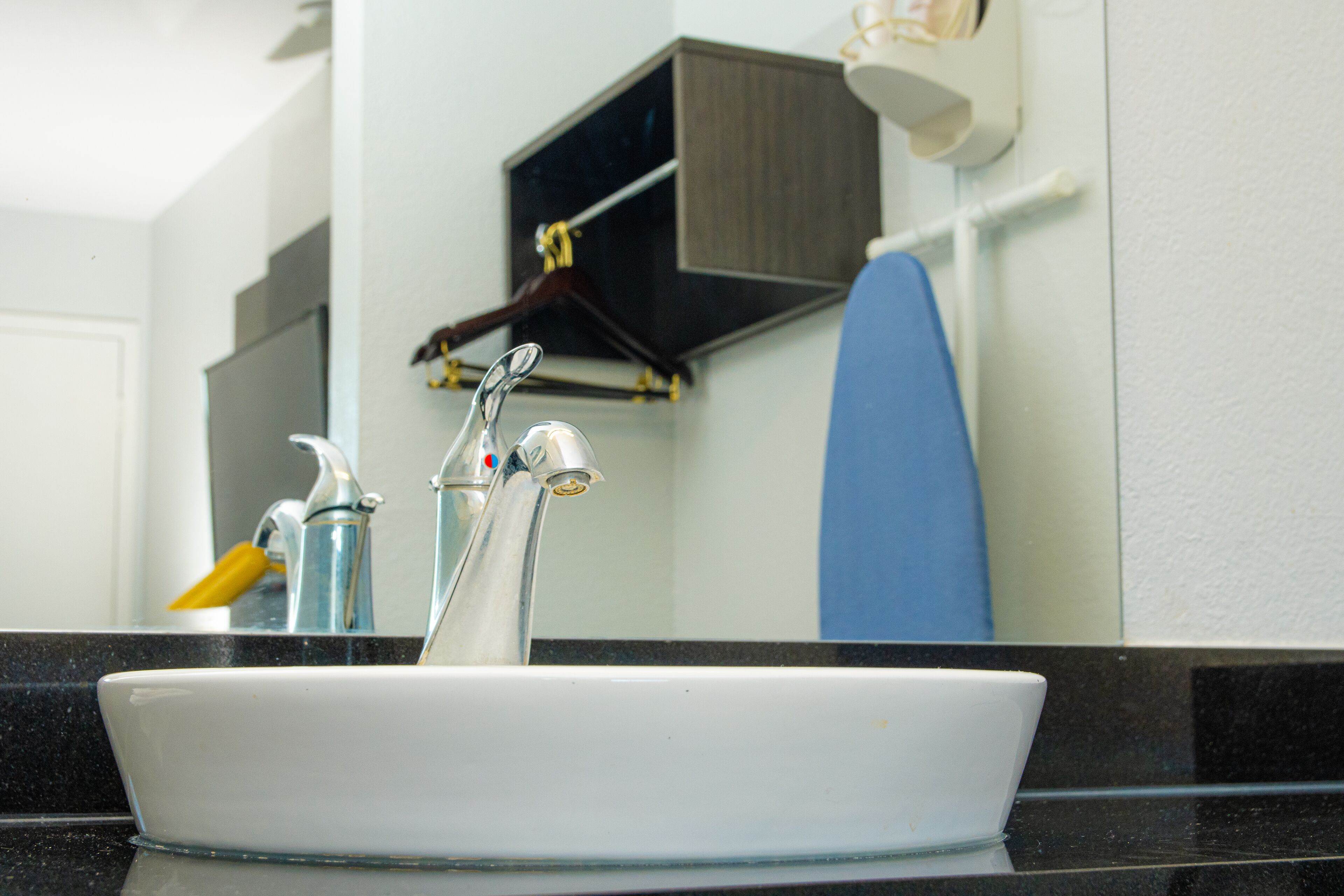 Un lavabo dans une salle de bain, avec un miroir au-dessus.