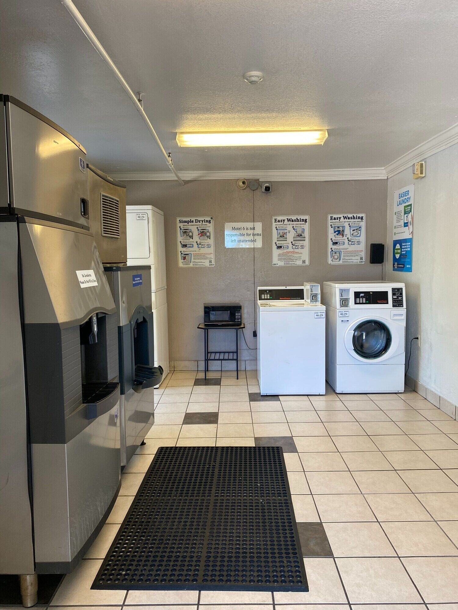 A laundry facility with a washing machine, dryer, and a vending machine.