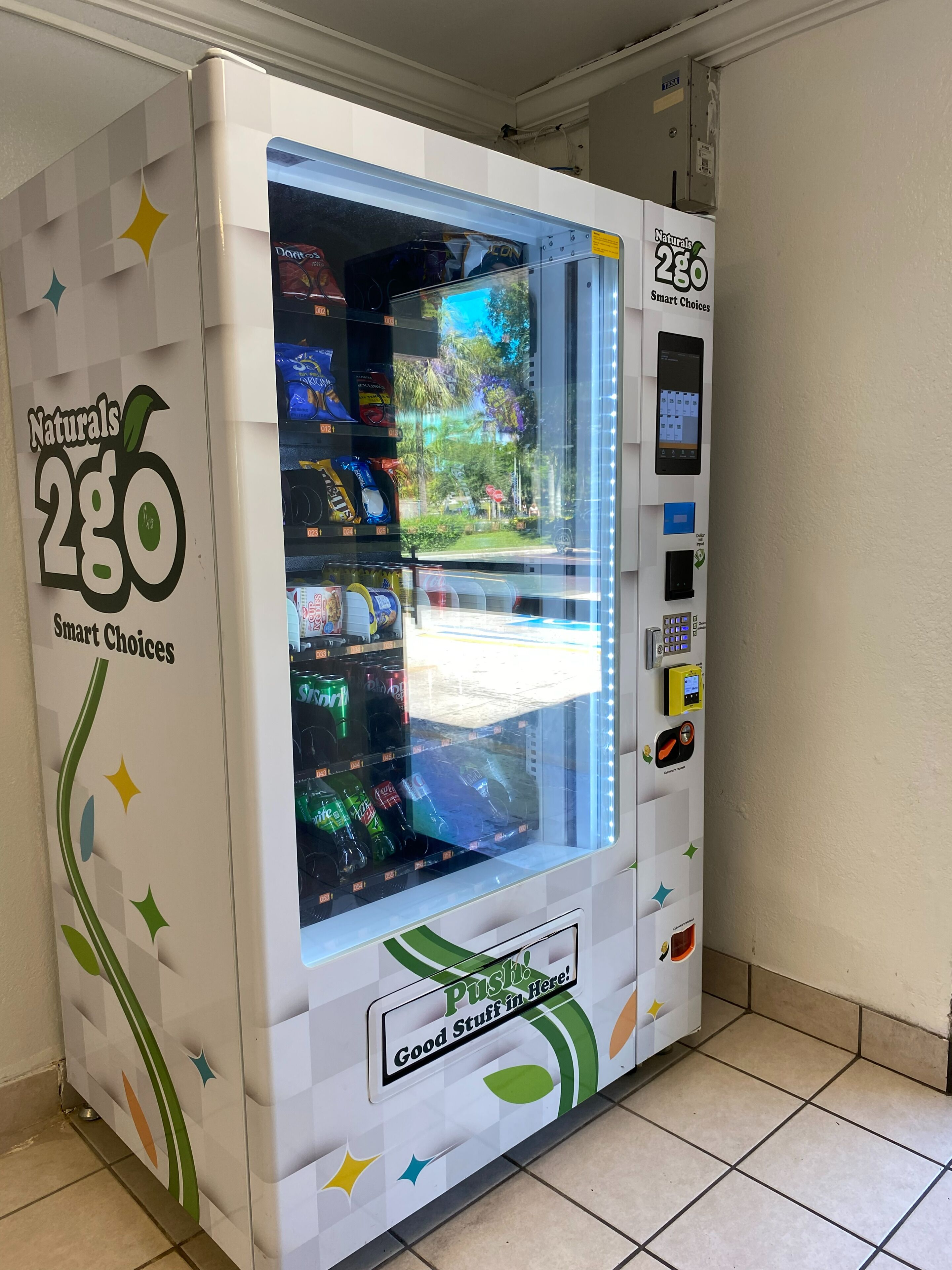 A vending machine labeled "Naturals 286 Smart Choices" with a variety of snacks and drinks inside.