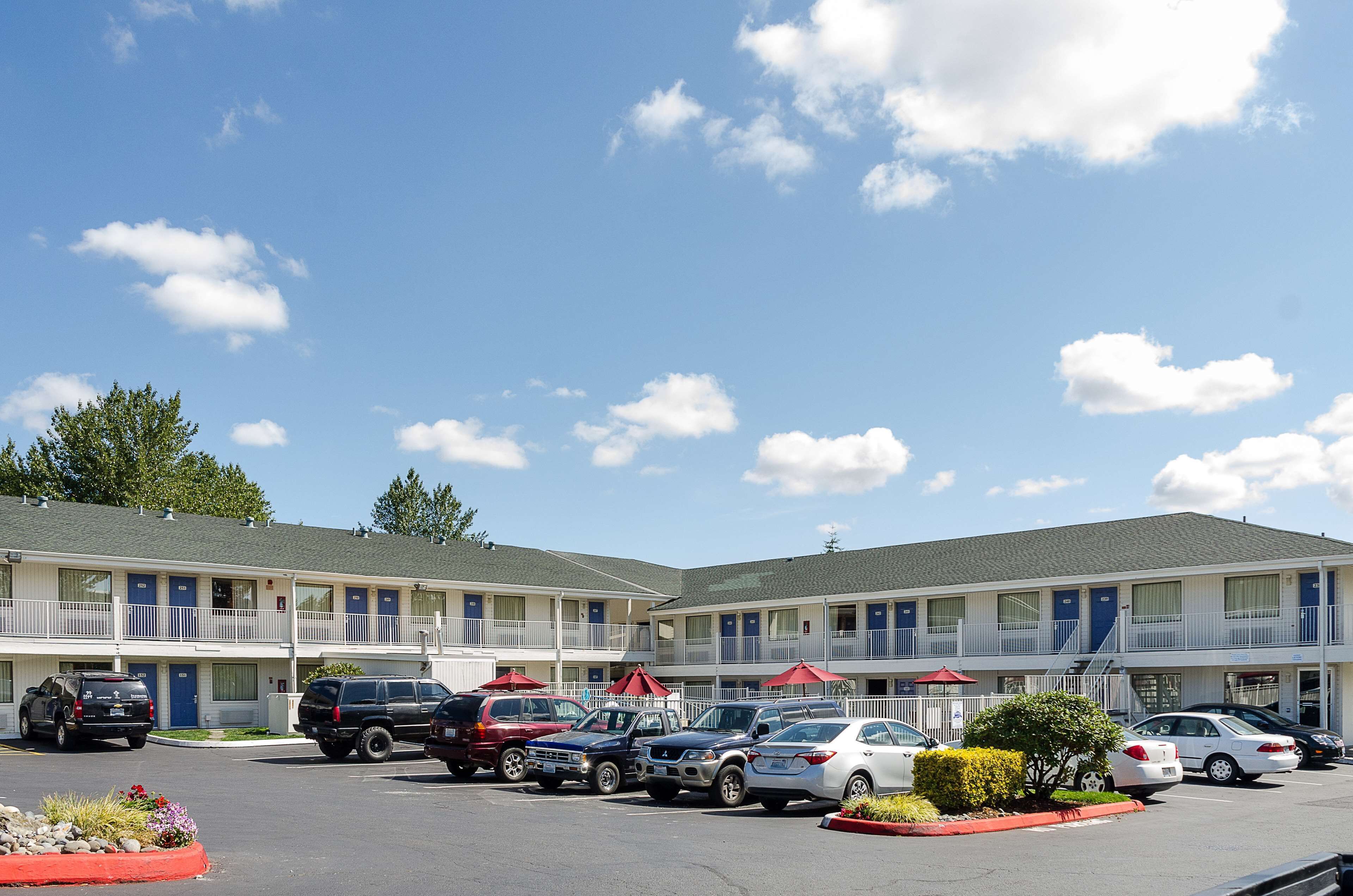 A motel with multiple rooms, a parking lot, and a small garden area.