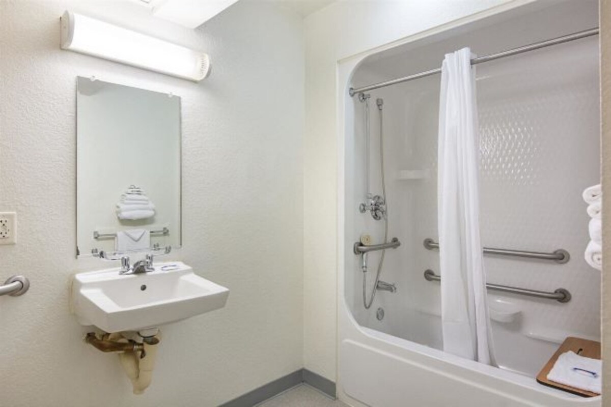 Une salle de bain équipée d’un lavabo, d’un miroir et d’une douche à l’italienne avec une porte en verre.