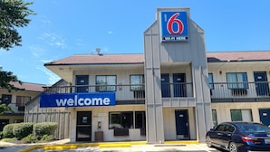 Un motel avec une enseigne « Bienvenue », une autre indiquant « Motel 6 » et une troisième annonçant la présence du « Wi-Fi ».