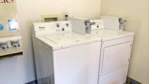 A front view of a laundry room with two stacked front-loading washing machines and a dryer. - Motel 6 Dalton, GA (Dalton)