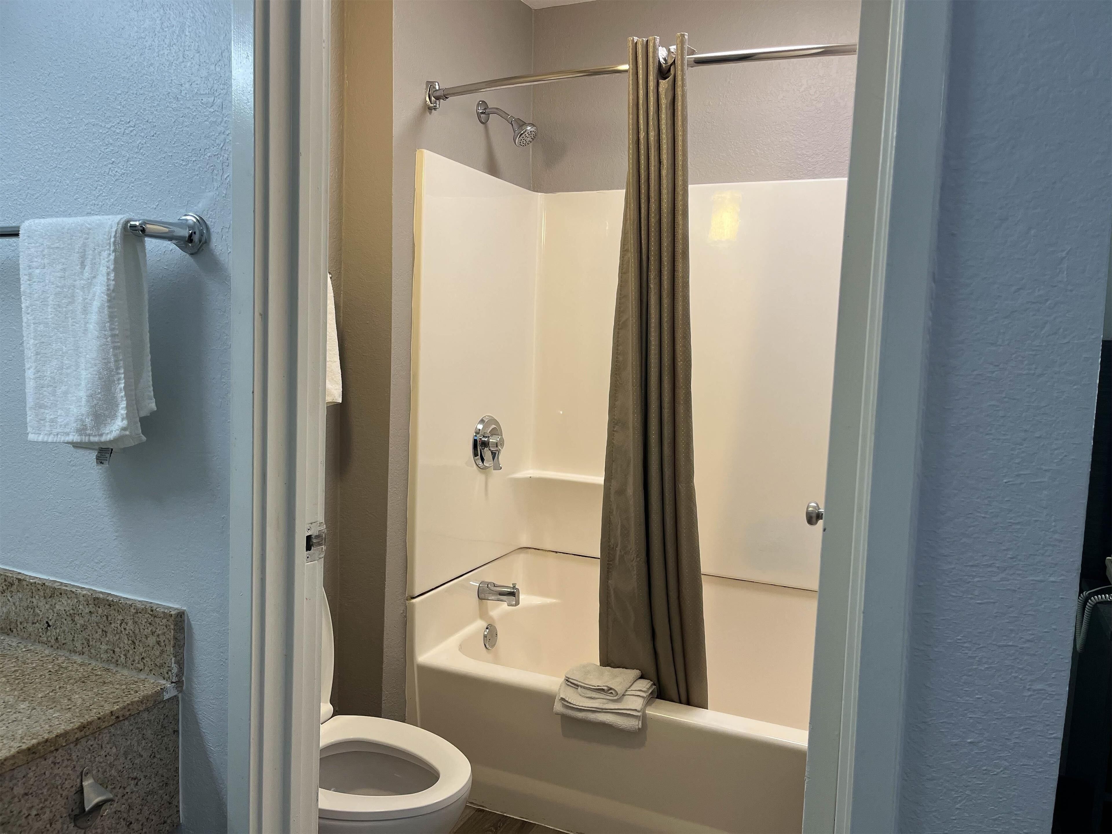 Ein Badezimmer mit Toilette, Badewanne und Duschvorhang.