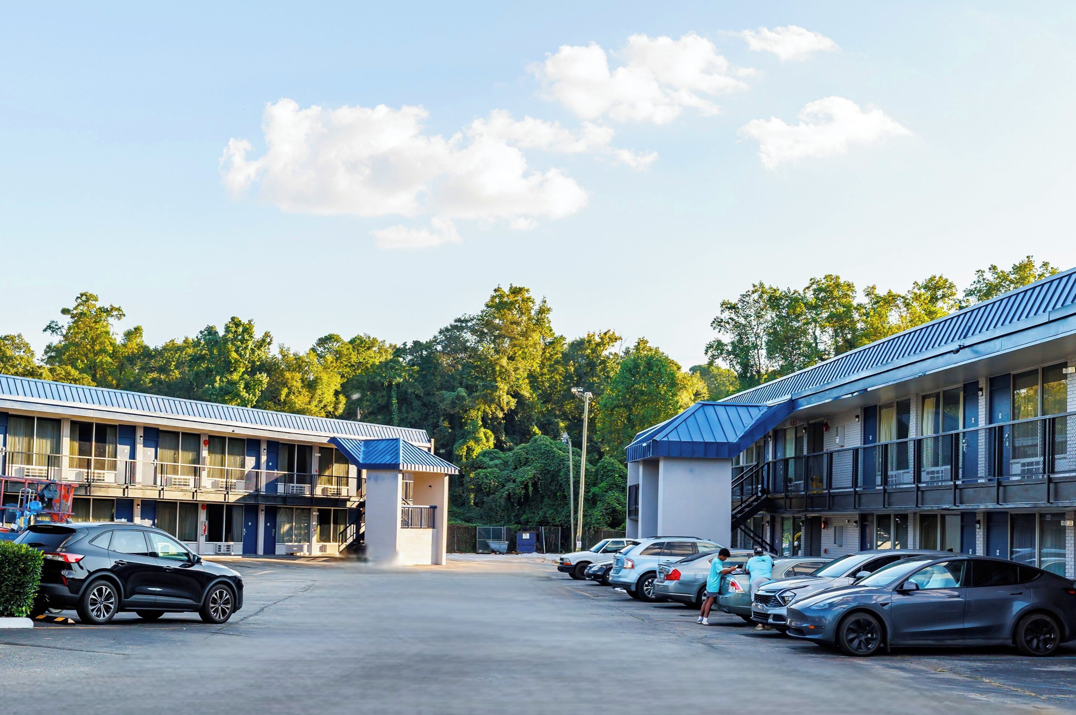 A motel with multiple rooms, a parking lot, and a small building in the center.