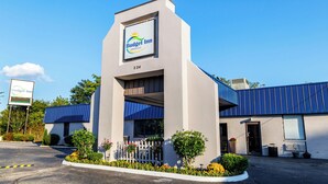 A Budget Inn with a modern design, featuring a prominent sign, a parking lot, and a well-maintained exterior with a blue roof and white walls. - Budget Inn Greenville By Hotel O I-85  (Greenville)
