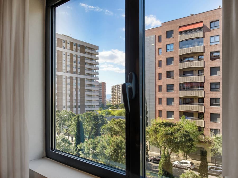 A view from a window of a multi-story building with balconies and a clear sky.