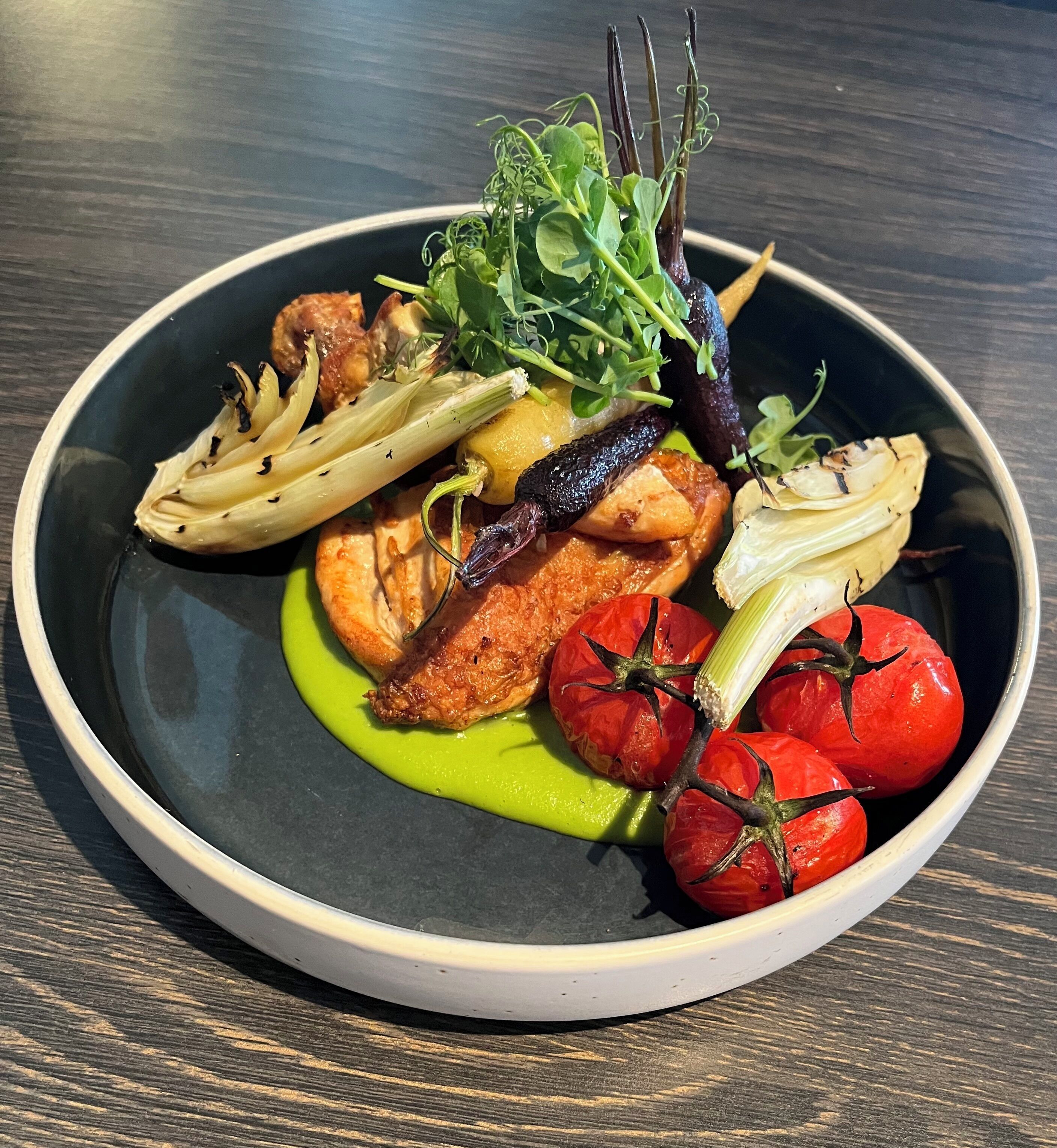 A plate of food with various vegetables and a piece of meat.