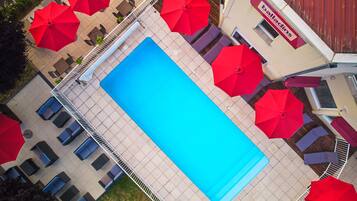 Una piscina al aire libre de temporada, sombrillas