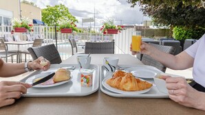 A dining table with breakfast items, outdoor seating, and a view of the sky. - The Originals City, Hôtel Restaurant L'Ormichal Dijon Sud. (Marsannay-la-Cote)