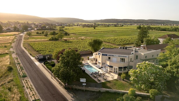 A hotel with a pool, surrounded by vineyards, and a road nearby. - The Originals City, Hôtel Restaurant L'Ormichal Dijon Sud. (Marsannay-la-Cote)