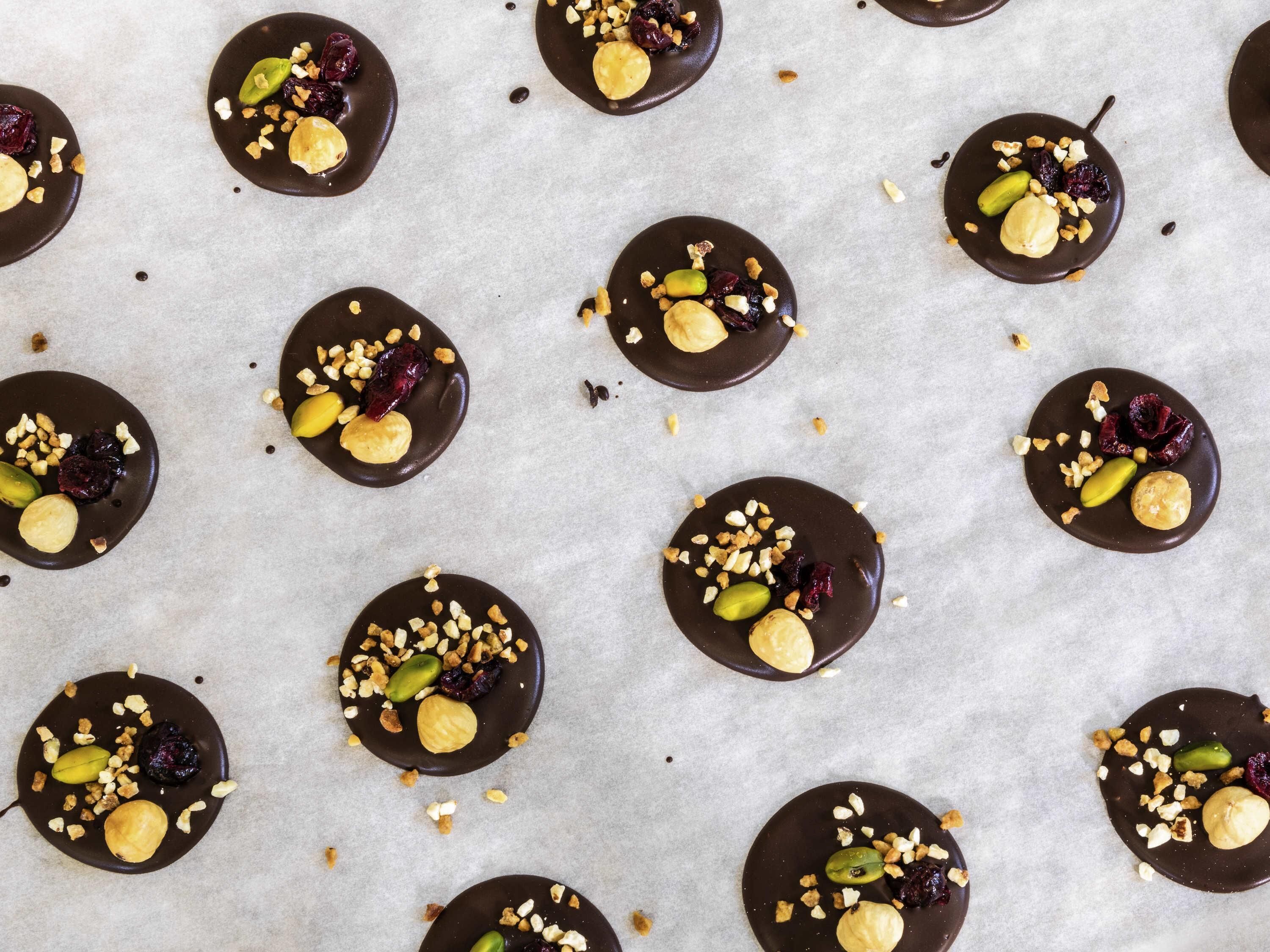 Un diseño de postres cubiertos de chocolate, con nueces y frutas deshidratadas.