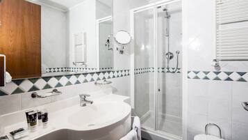 Un bagno con un lavandino grande, uno specchio, una doccia e un WC.