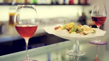 A bar setting with two wine glasses and a plate of food.