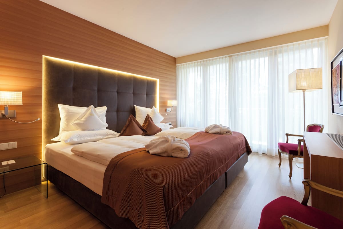 Una habitación de hotel con una cama grande, un escritorio y una silla.