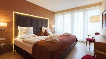 Een hotelkamer met een groot bed, een bureau en een stoel.