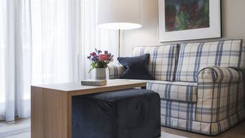 Una sala moderna con una mesa de centro de madera, un sofá escocés y un cojín azul oscuro.