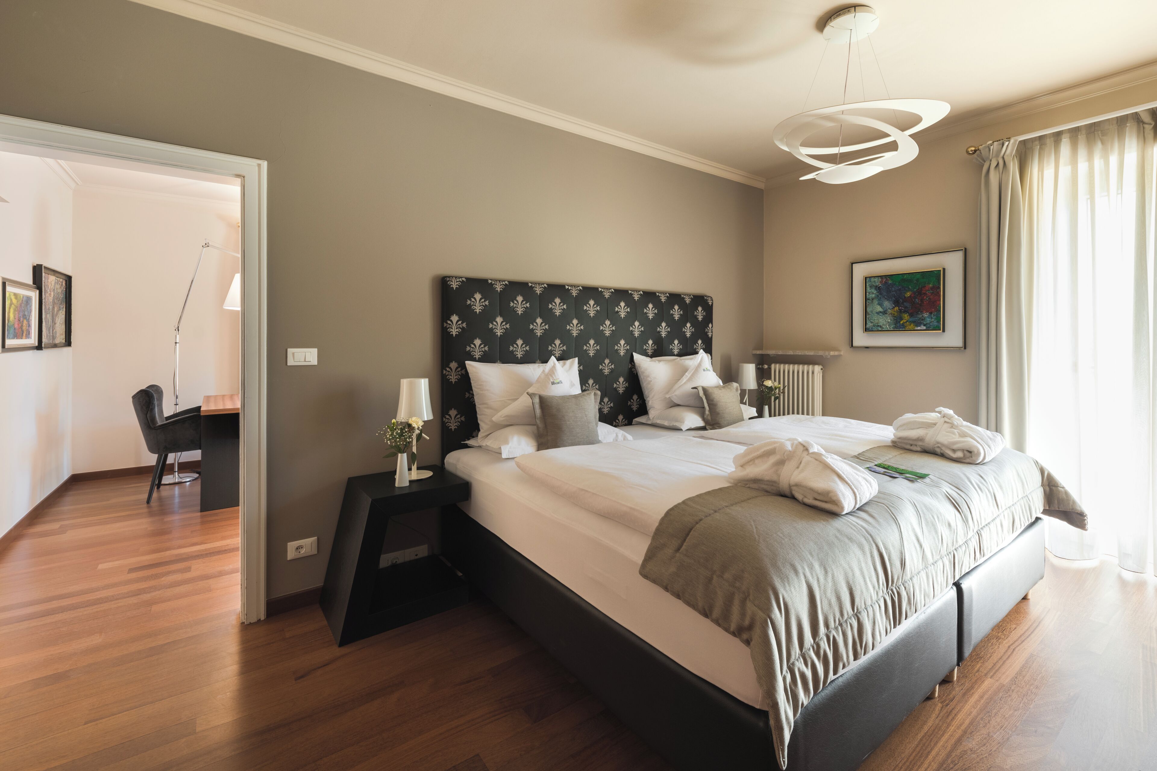Una habitación de hotel moderna con una cama grande, un escritorio y una silla.