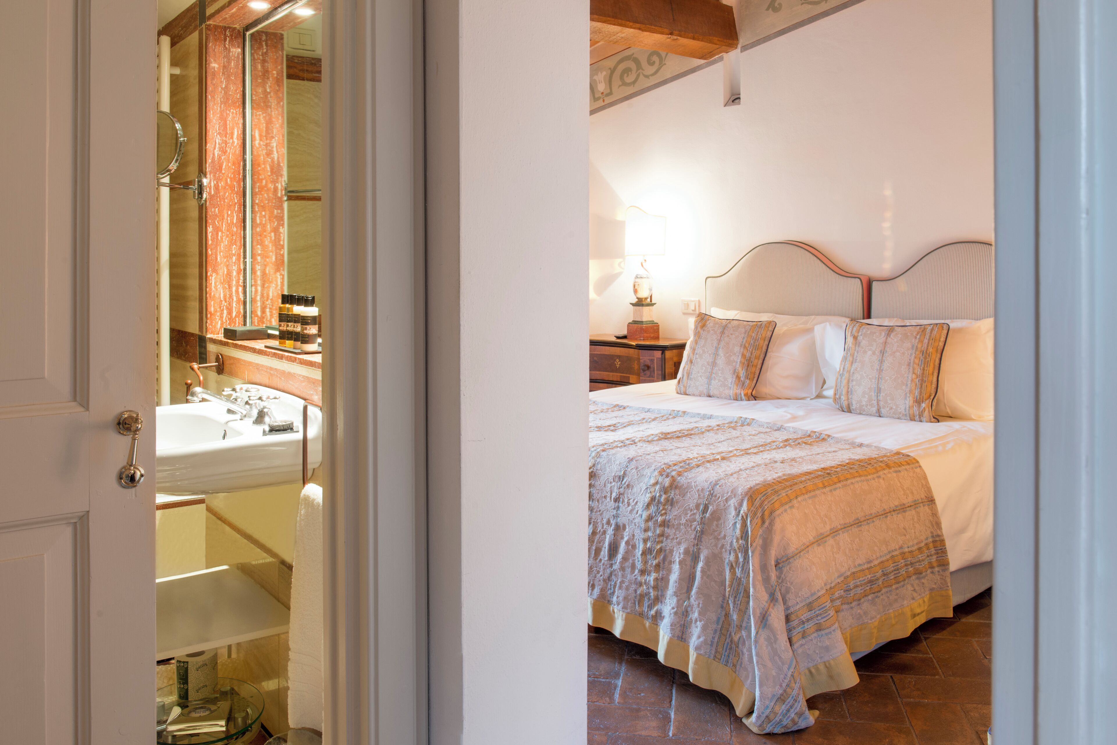 A bedroom with a bed, a nightstand, and a mirror.