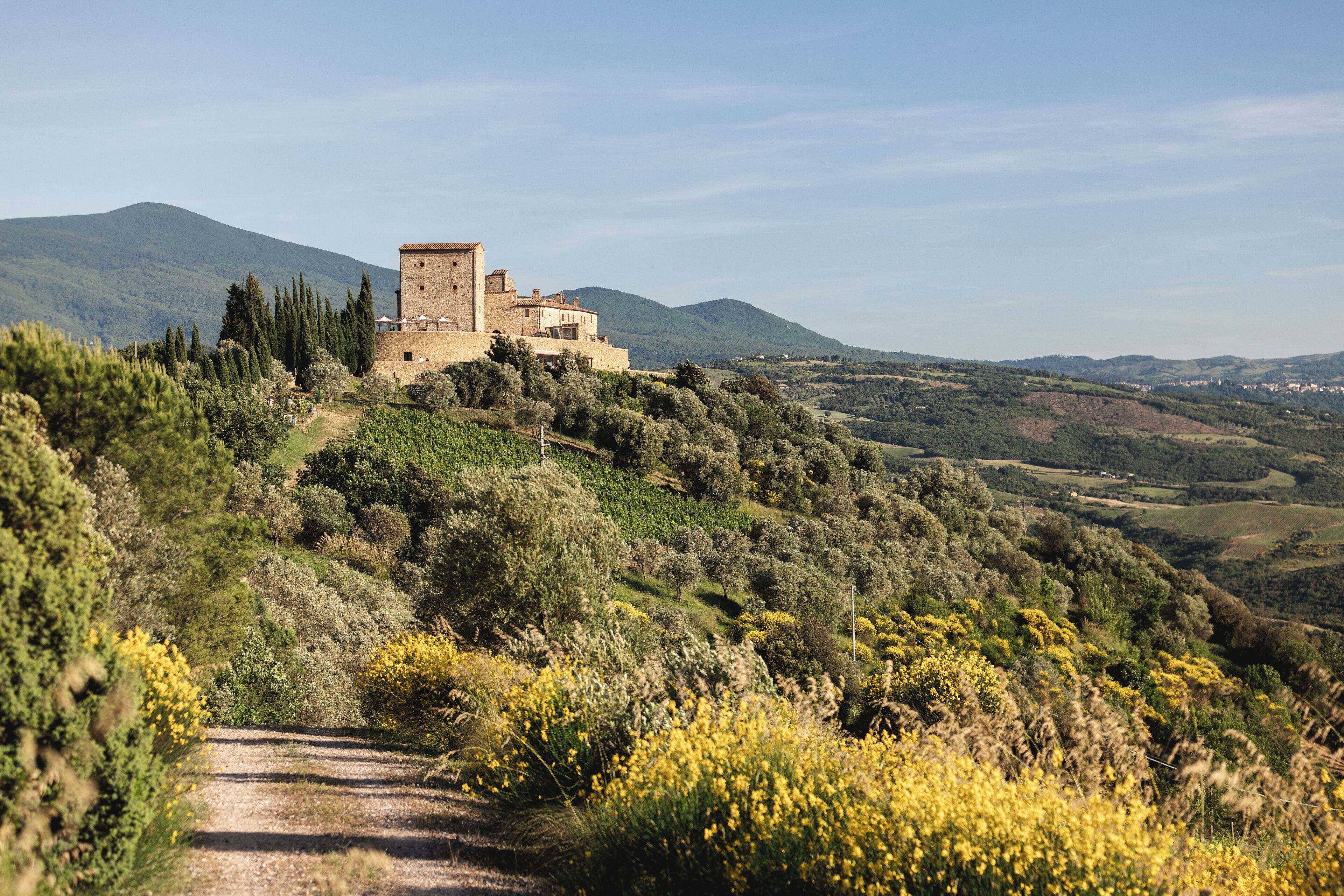 A historic building on a hillside with a dirt path leading to it.