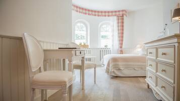 Un dormitorio con cama, cómoda, silla y ventana con cortina a cuadros.