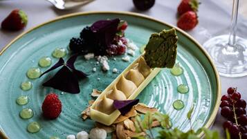 Un plato de postre con diversas frutas y una copa de vino.