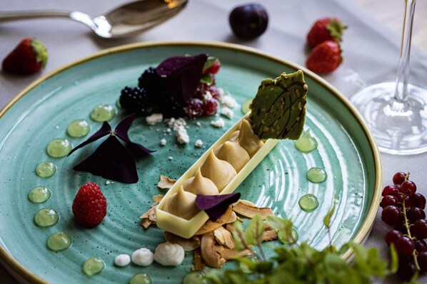 A dessert plate with various fruits and a glass of wine.