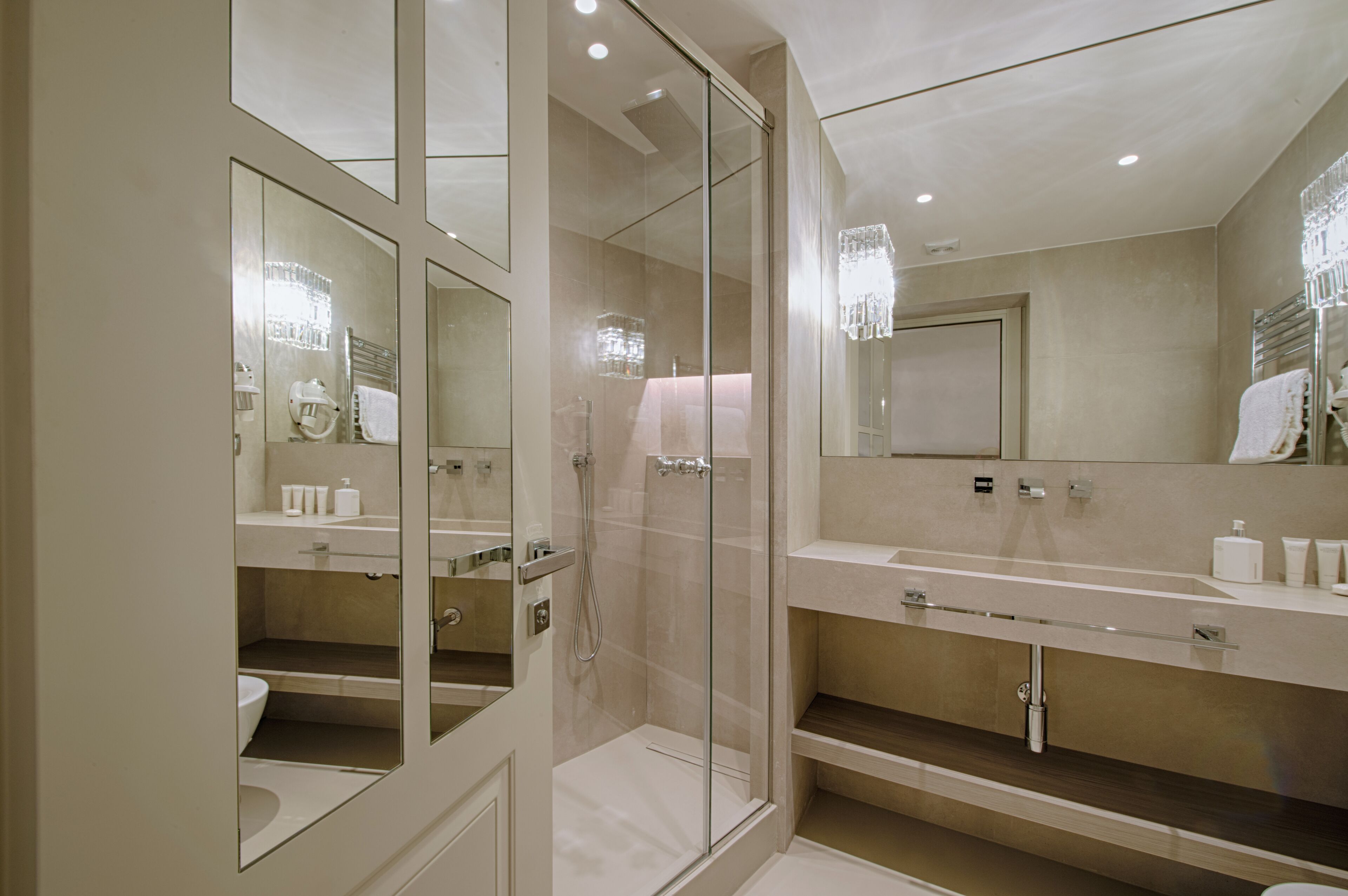 A modern bathroom with a glass-enclosed shower, a large mirror, and a vanity with a countertop.