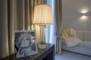 A modern living room with a lamp, a framed picture, and a sofa.