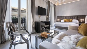 Habitación de hotel moderna con una cama grande, televisión, escritorio y una mesa de centro de vidrio.