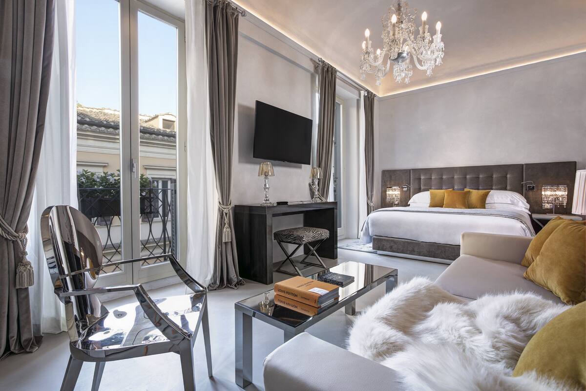Une chambre d’hôtel moderne équipée d’un grand lit, d’une télévision, d’un bureau et d’une table basse en verre.