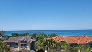 A coastal residential area with houses featuring red-tiled roofs and a clear view of the ocean. - Aqualuna Beach Resort (Korora)