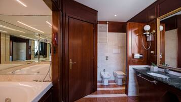 Ein modernes Badezimmer mit einer großen Badewanne, einer separaten Toilette und einem Waschtisch.