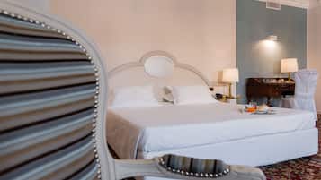Ein Hotelzimmer mit einem Bett, zwei Nachttischlampen, einem Nachttisch und einem Sessel.