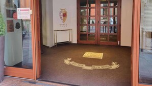 Een hotelentree met een glazen deur, een bord dat een Michelino-onderscheiding uit 2018 aangeeft, en een logo aan de muur.