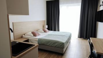 Una habitación de hotel con una cama, un escritorio y un televisor.