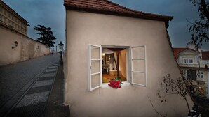 Ein Gebäude mit rotem Ziegeldach und einem Fenster mit geöffneten Klappläden.