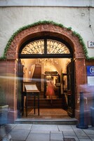 Una entrada con una reja de hierro forjado, un mostrador de recepción y una escalera que conduce al interior.
