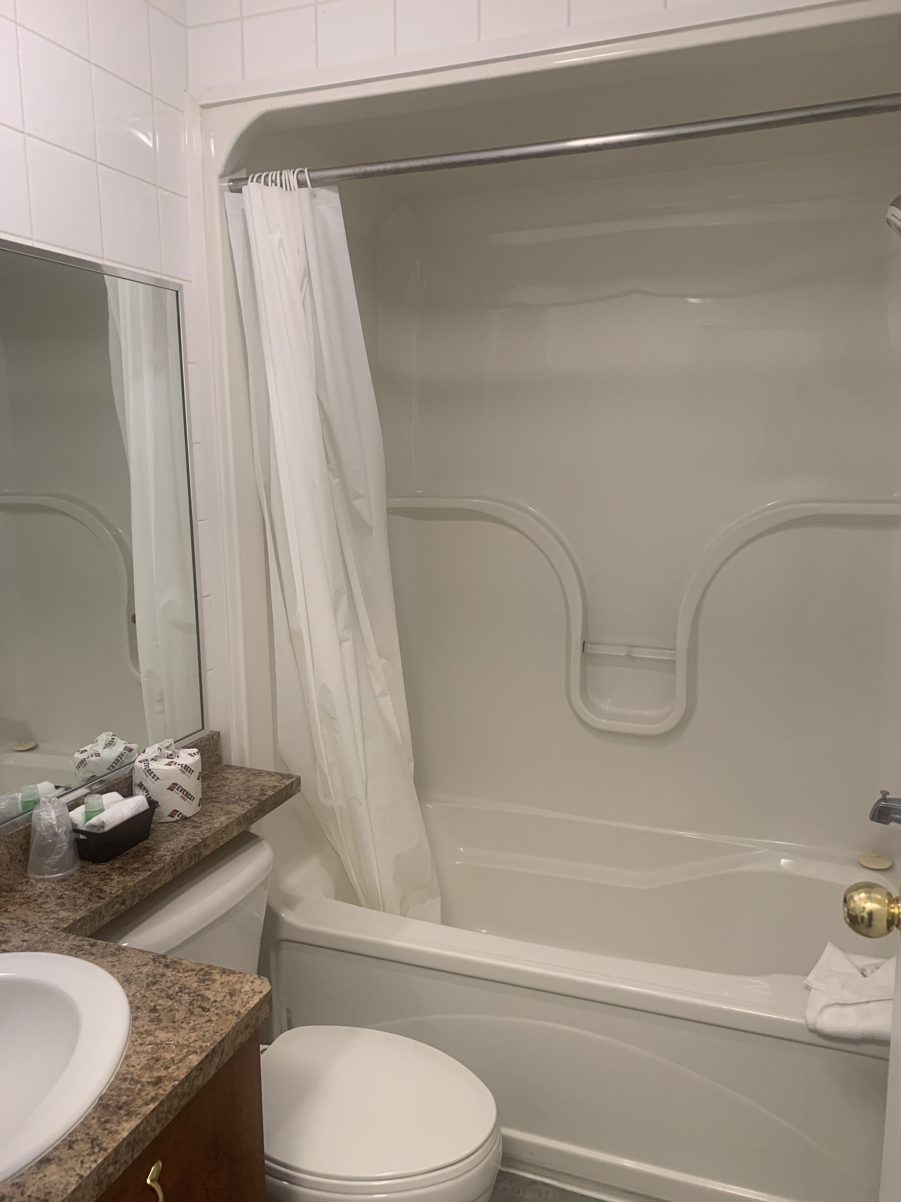 A bathroom with a bathtub, a toilet, a sink, and a mirror.
