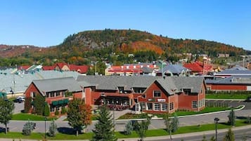 A town with a mix of commercial and residential buildings, a main road, and a hilly backdrop.