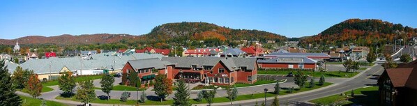 A town with a mix of commercial and residential buildings, a main road, and a hilly backdrop.