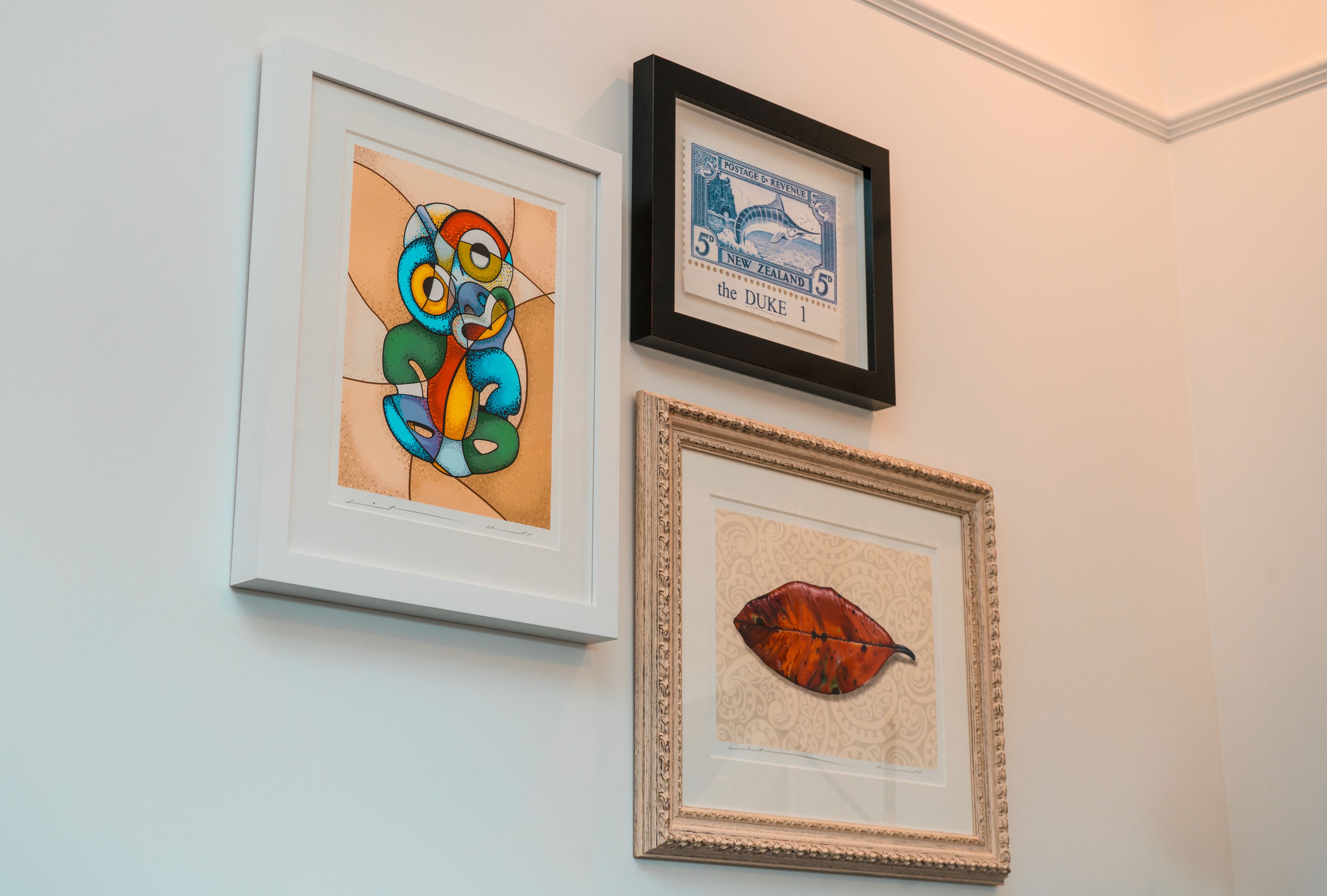 Tres obras de arte enmarcadas en una pared.