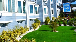 A multi-story hotel with bay windows and a well-maintained lawn.