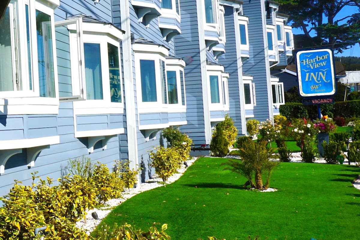 A multi-story hotel with bay windows and a well-maintained lawn.